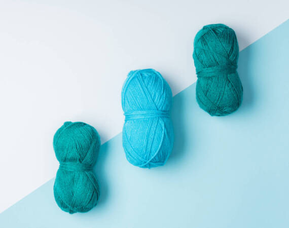 flat lay with arranged blue yarn clews on white and blue background